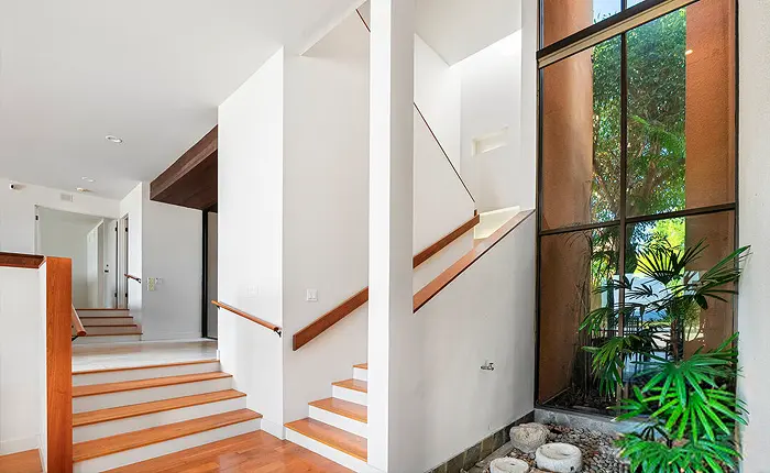 This Malibu Buff and Hensman home has a multilevel floor plan, expansive gallery walls and an indoor planter with water feature create a rich residential environment pulled right from a five-star hotel.