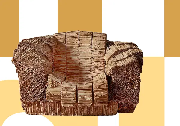Frank Gehry’s Beaver Chair is made entirely from stacked and layered cardboard, set against a background of white and yellow geometric shapes. Its rough, textured look highlights the corrugated layers.