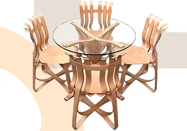 A round glass-top Hat Trick dining set, designed by Frank Gehry, includes four uniquely crafted wooden chairs with curved, slatted backs and legs, all arranged in a geometric pattern on a white and beige background.